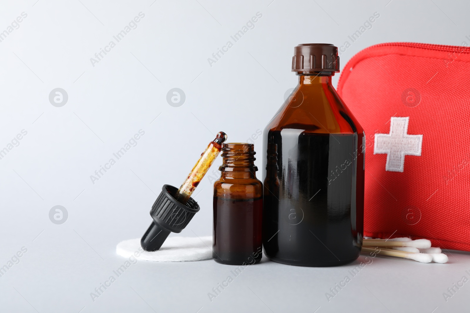 Photo of Topical iodine and other first aid kit components on light background. Space for text