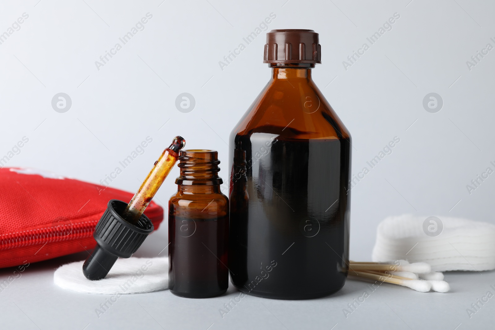 Photo of Topical iodine and other first aid kit components on light background