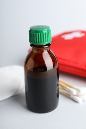 Photo of Topical iodine and other first aid kit components on light background, closeup