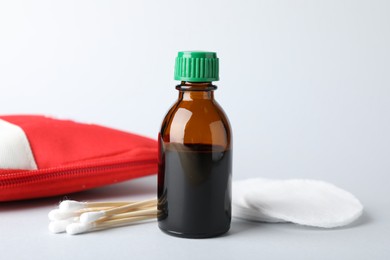 Photo of Topical iodine and other first aid kit components on light background, closeup