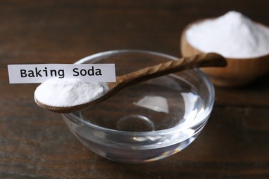 Photo of Glass of water and baking soda on wooden table