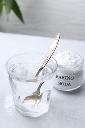 Photo of Glass of water and baking soda on white table. Space for text