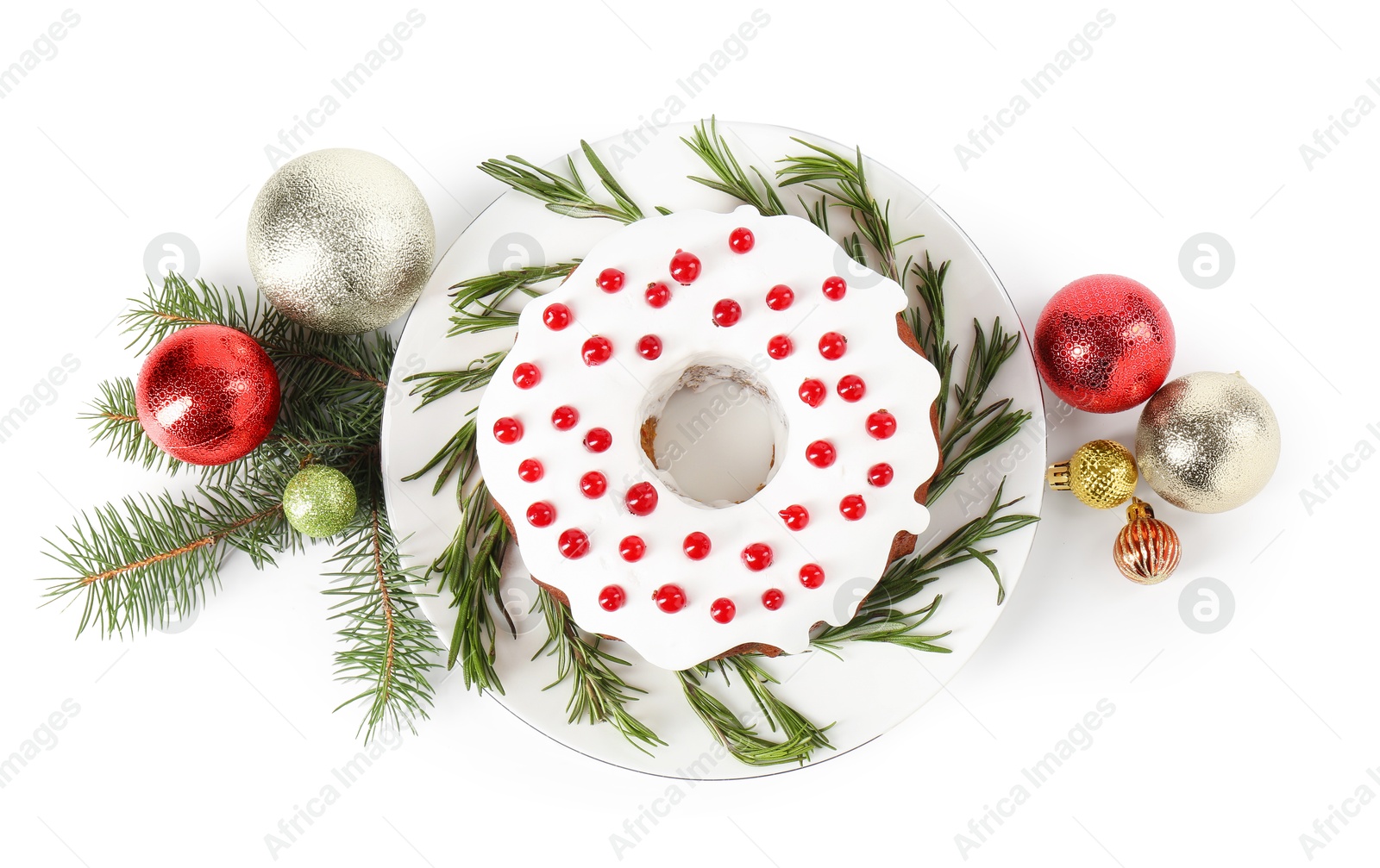 Photo of Tasty Christmas cake with red currants, rosemary, fir branches and baubles isolated on white, top view