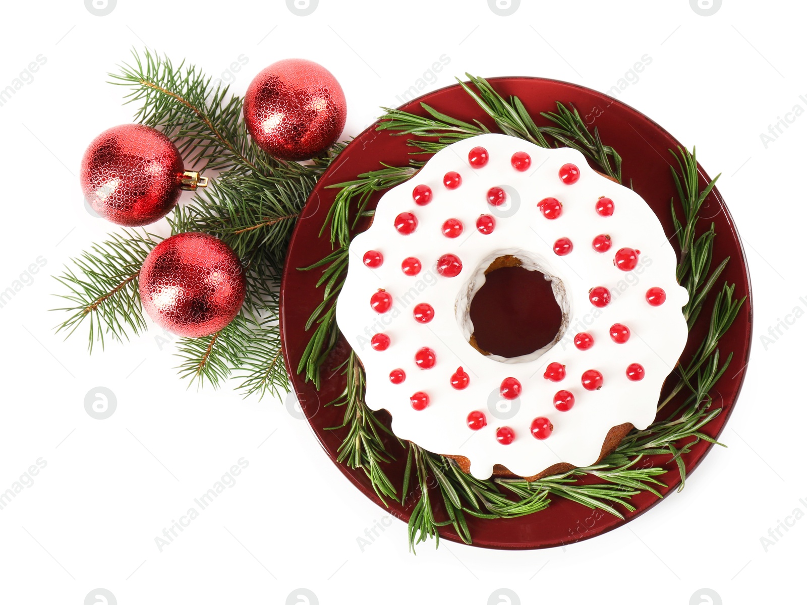 Photo of Tasty Christmas cake with red currants, rosemary, fir branches and baubles isolated on white, top view