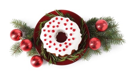 Photo of Tasty Christmas cake with red currants, rosemary, fir branches and baubles isolated on white, top view