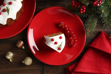 Photo of Pieces of traditional classic Christmas cake and decor on wooden table, flat lay