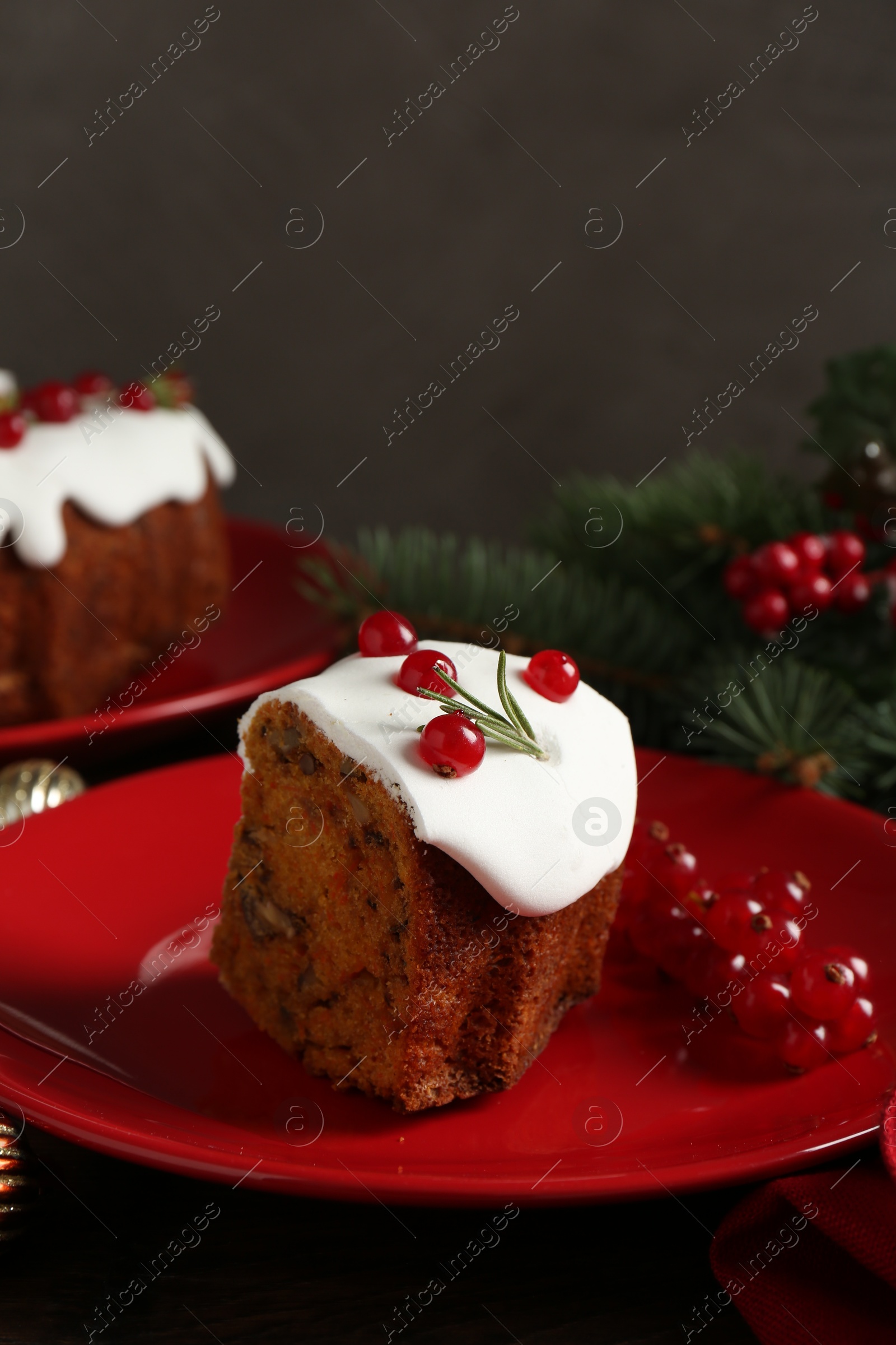 Photo of Piece of traditional Christmas cake decorated with red currants and rosemary on table