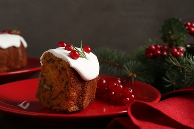 Photo of Piece of traditional Christmas cake decorated with red currants and rosemary on table