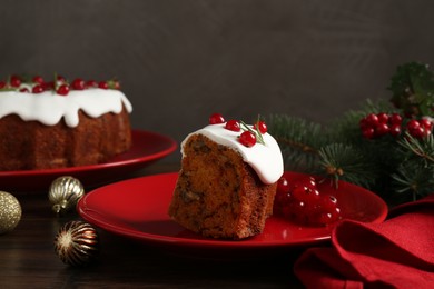 Photo of Piece of traditional classic Christmas cake and decor on wooden table