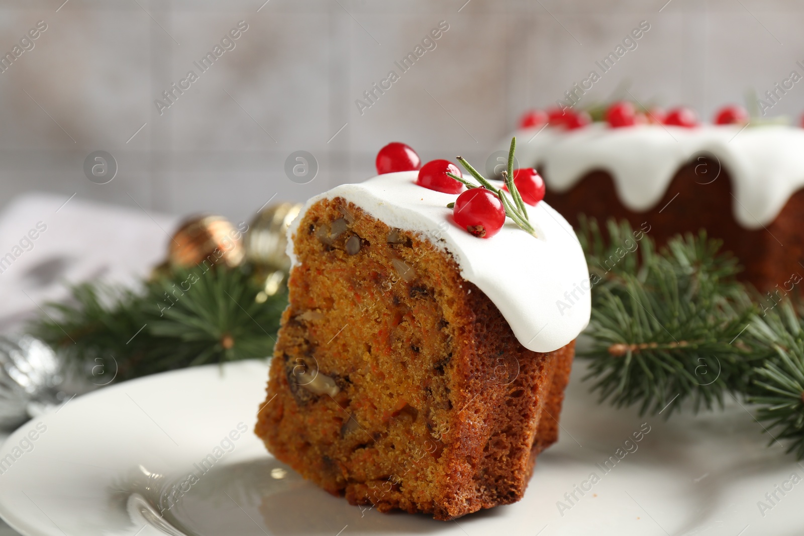 Photo of Piece of traditional Christmas cake decorated with red currants and rosemary on table, closeup