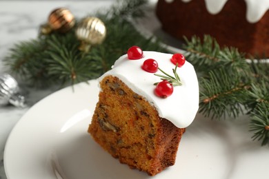 Photo of Piece of traditional Christmas cake decorated with red currants and rosemary on table, closeup