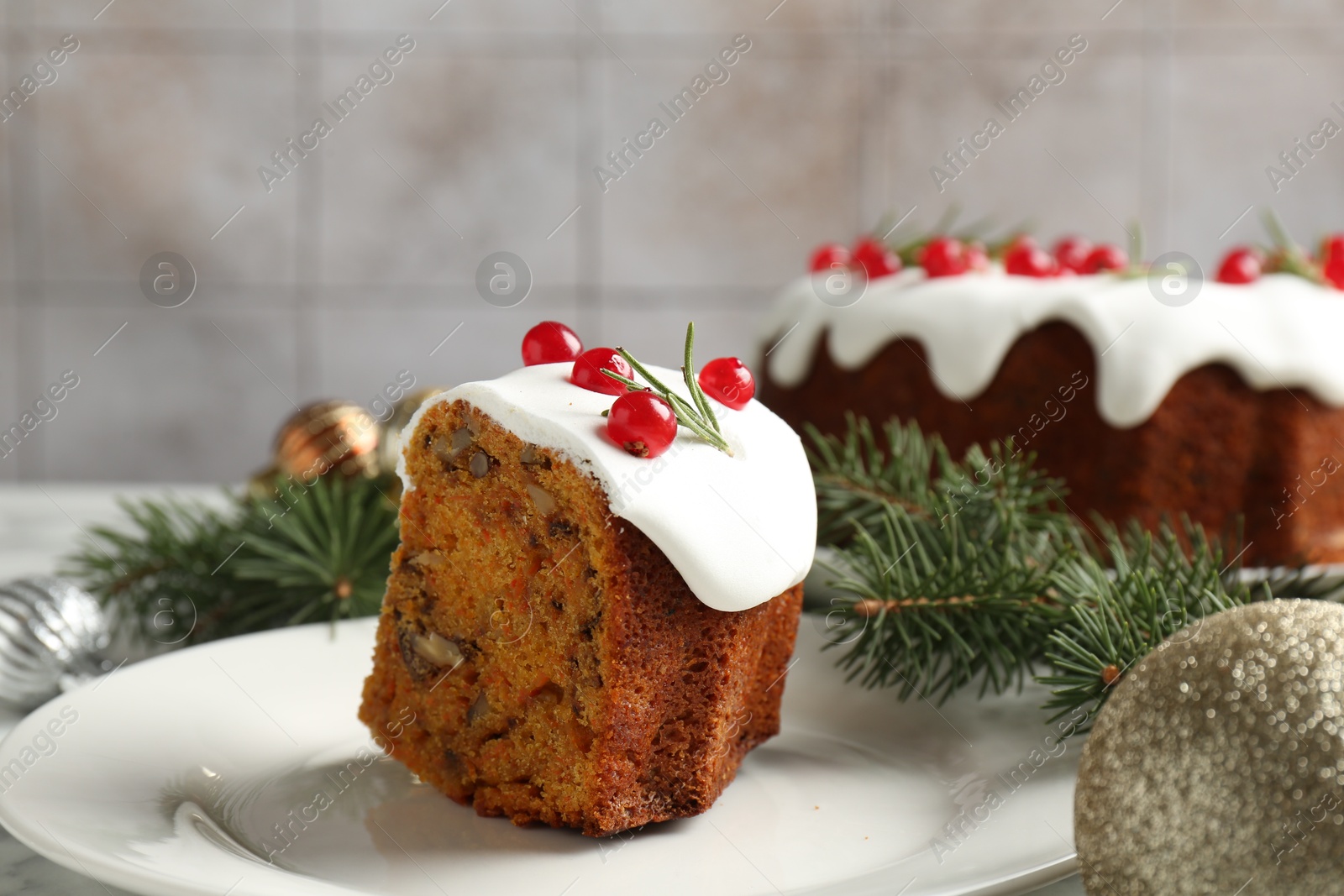 Photo of Piece of traditional Christmas cake decorated with red currants and rosemary on table