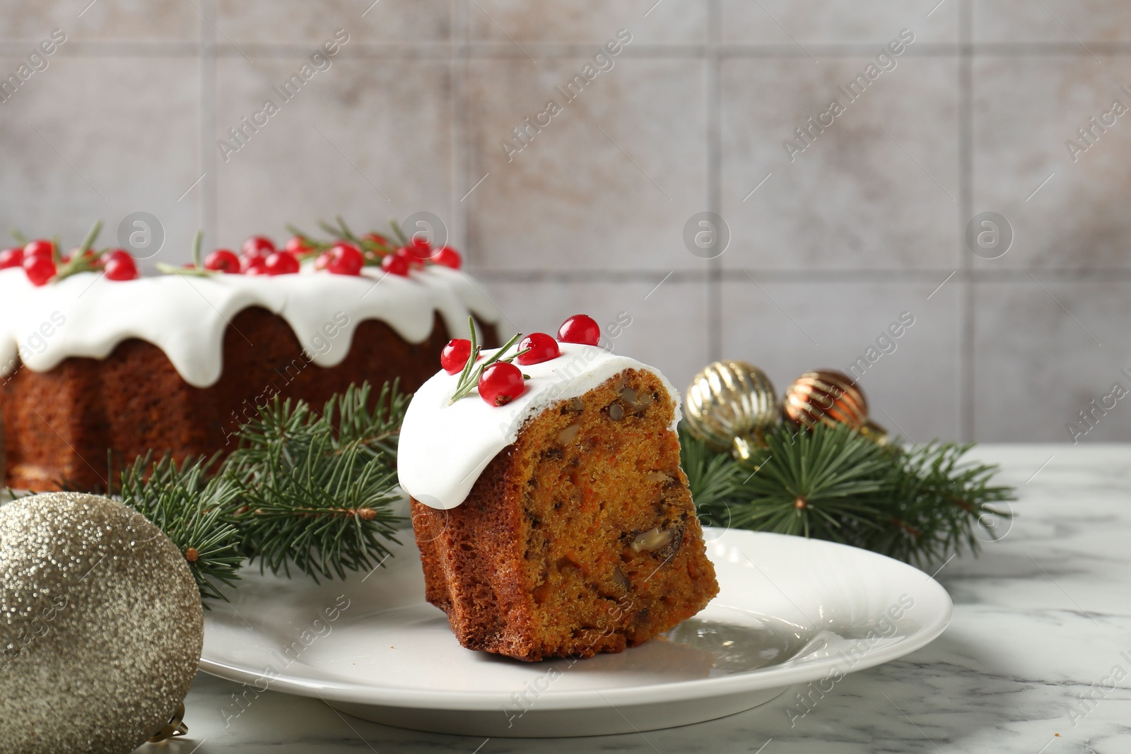 Photo of Piece of traditional classic Christmas cake and decor on white marble table