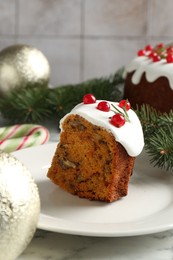 Photo of Traditional Christmas cake decorated with red currants and rosemary on light marble table