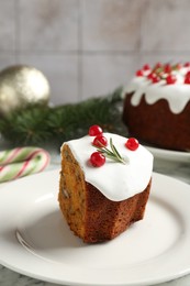 Photo of Traditional Christmas cake decorated with red currants and rosemary on table