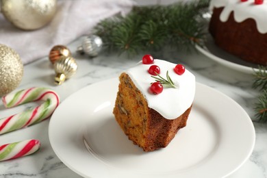 Photo of Piece of traditional classic Christmas cake and decor on white marble table