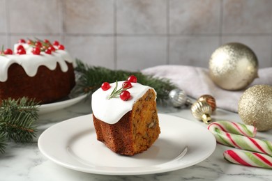 Photo of Piece of traditional classic Christmas cake and decor on white marble table