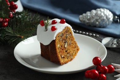 Photo of Piece of traditional classic Christmas cake and decor on gray textured table, closeup