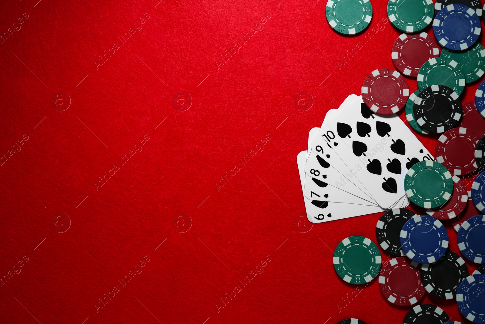 Photo of Playing cards and poker chips on red table, flat lay. Space for text