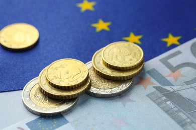 Photo of Coins and euro banknote on European Union flag, closeup