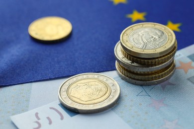 Photo of Coins and euro banknote on European Union flag, closeup