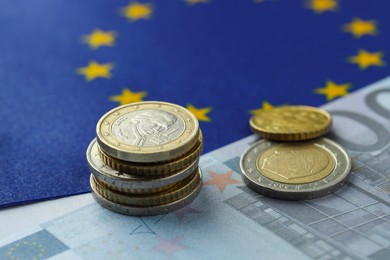 Photo of Coins and euro banknote on European Union flag, closeup