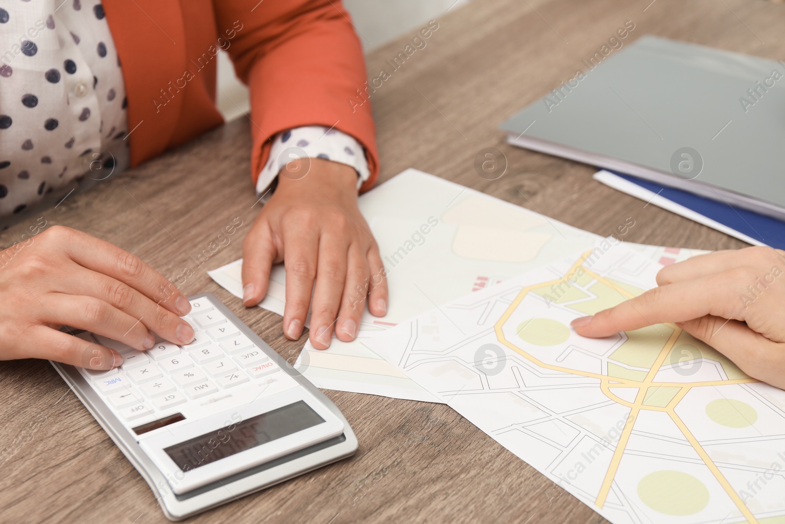 Photo of Real estate agent working with client at wooden table, closeup