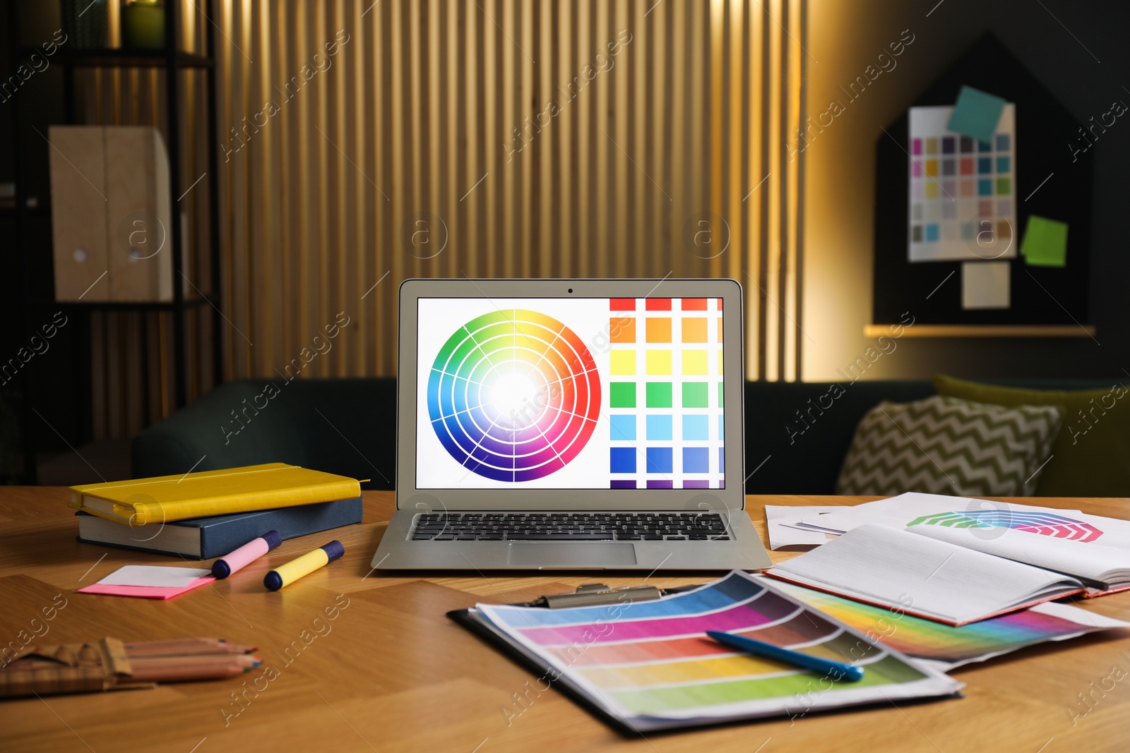 Photo of Designer's workplace with laptop, stationery and palettes on wooden table indoors