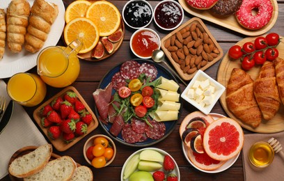 Photo of Different tasty food served for brunch on wooden table, flat lay