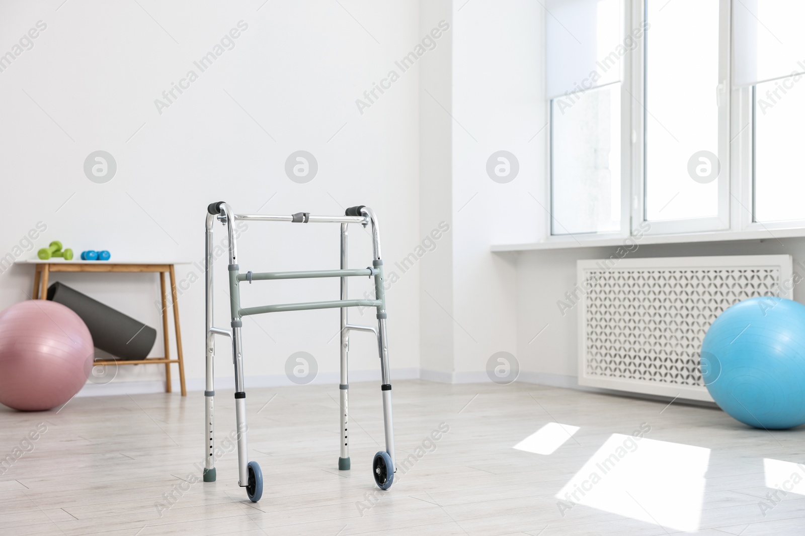 Photo of Metal walking frame in room. Medical equipment