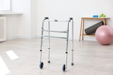 Photo of Metal walking frame in room. Medical equipment