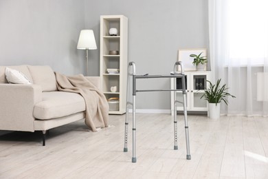 Photo of Metal walking frame in room. Medical equipment