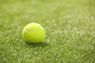 Photo of Tennis ball on green artificial grass, space for text