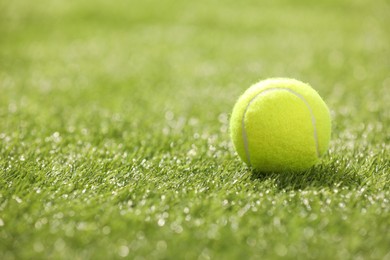 Photo of Tennis ball on green artificial grass, space for text