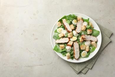 Photo of Tasty Caesar salad with chicken on light grey table, top view. Space for text