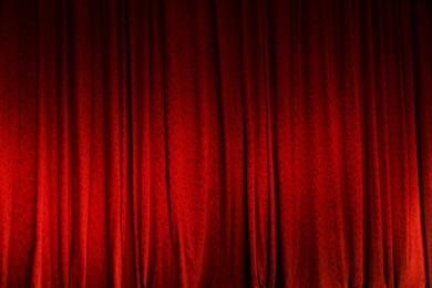 Photo of Elegant red curtains in theatre as background, closeup