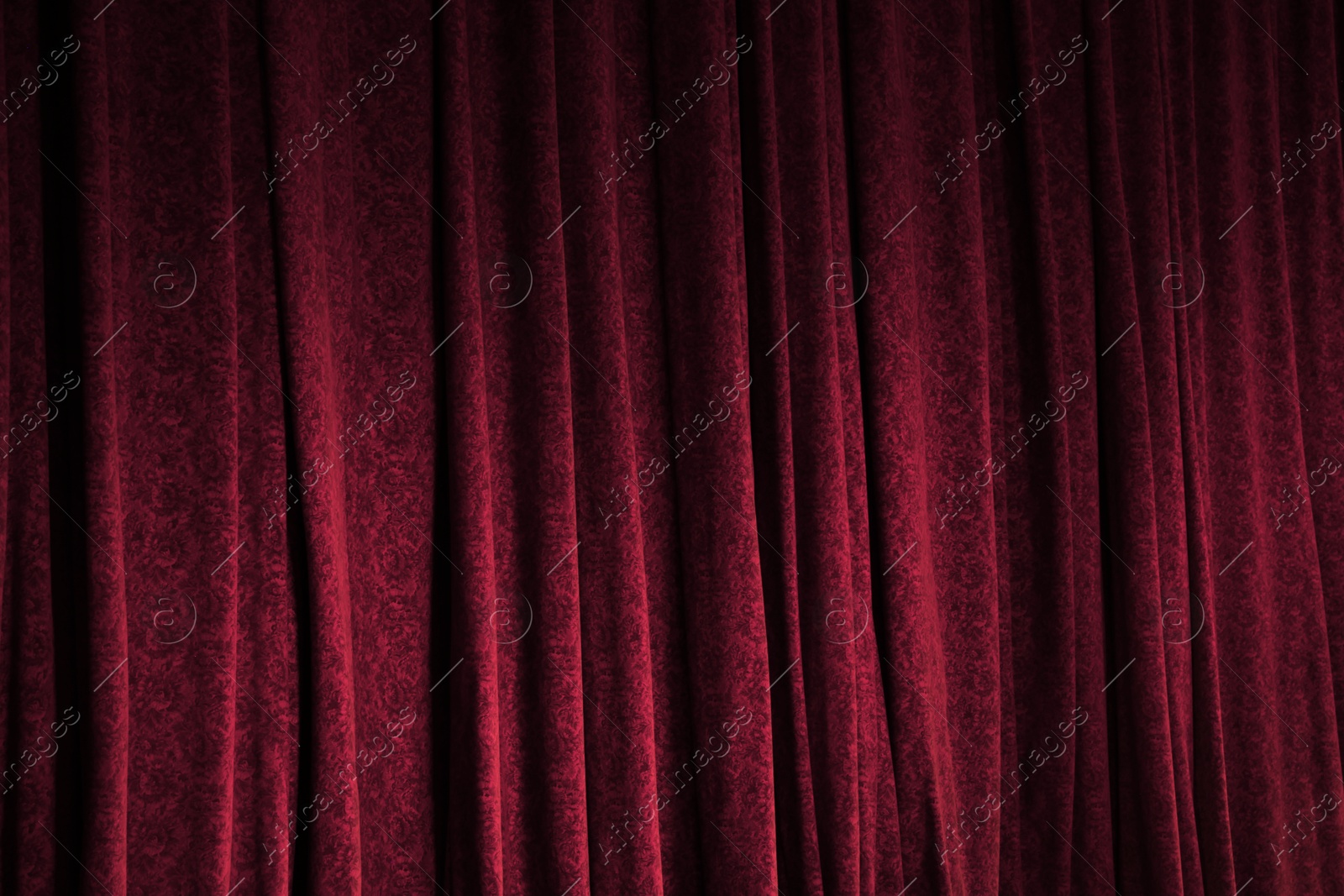 Photo of Elegant red curtains in theatre as background, closeup