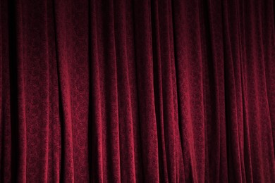 Photo of Elegant red curtains in theatre as background, closeup