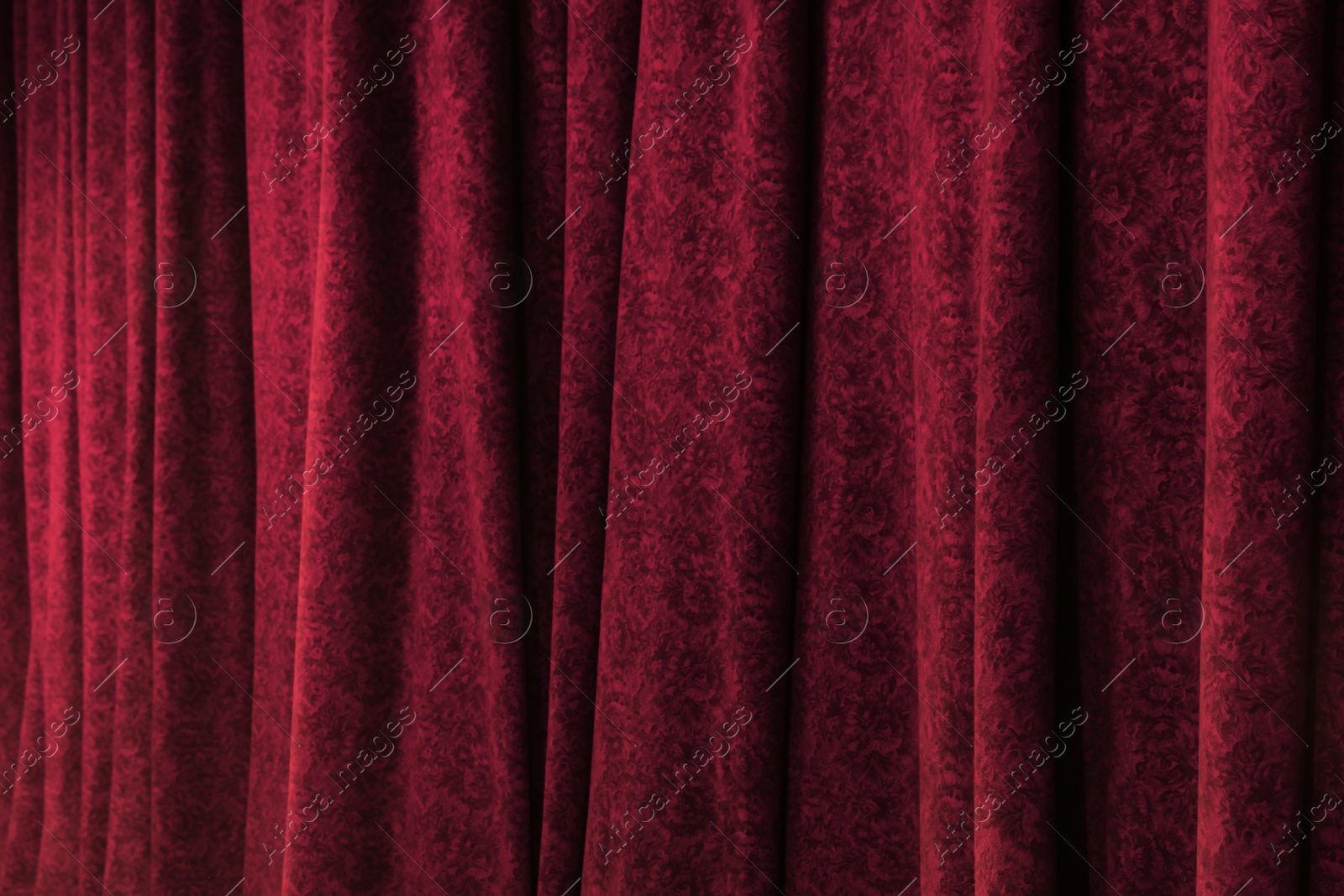 Photo of Elegant red curtains in theatre as background, closeup