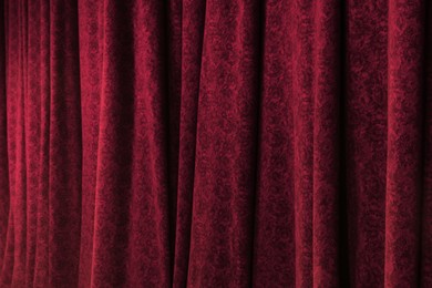 Photo of Elegant red curtains in theatre as background, closeup