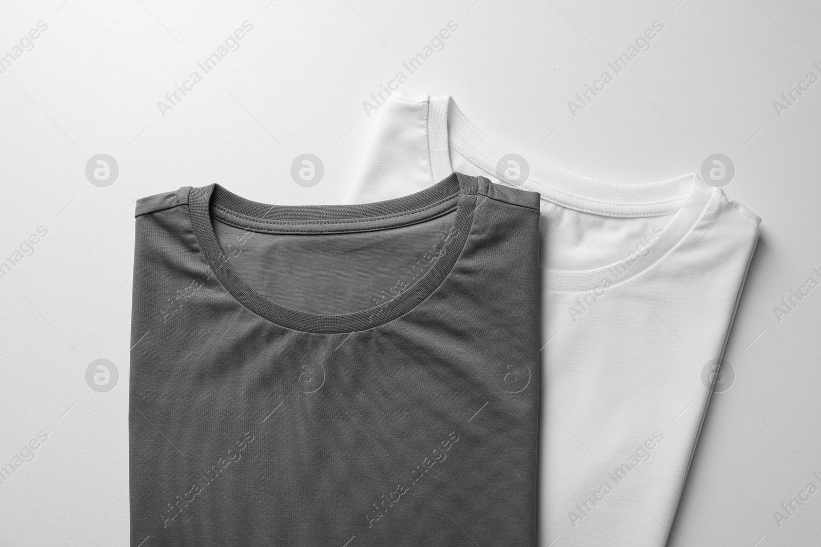 Photo of Different blank t-shirts on white background, top view. Mockup for design