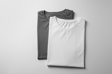 Photo of Different blank t-shirts on white background, top view. Mockup for design