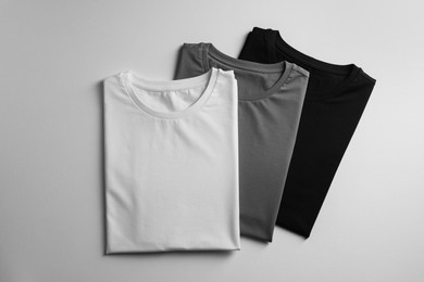 Photo of Different blank t-shirts on white background, top view. Mockup for design