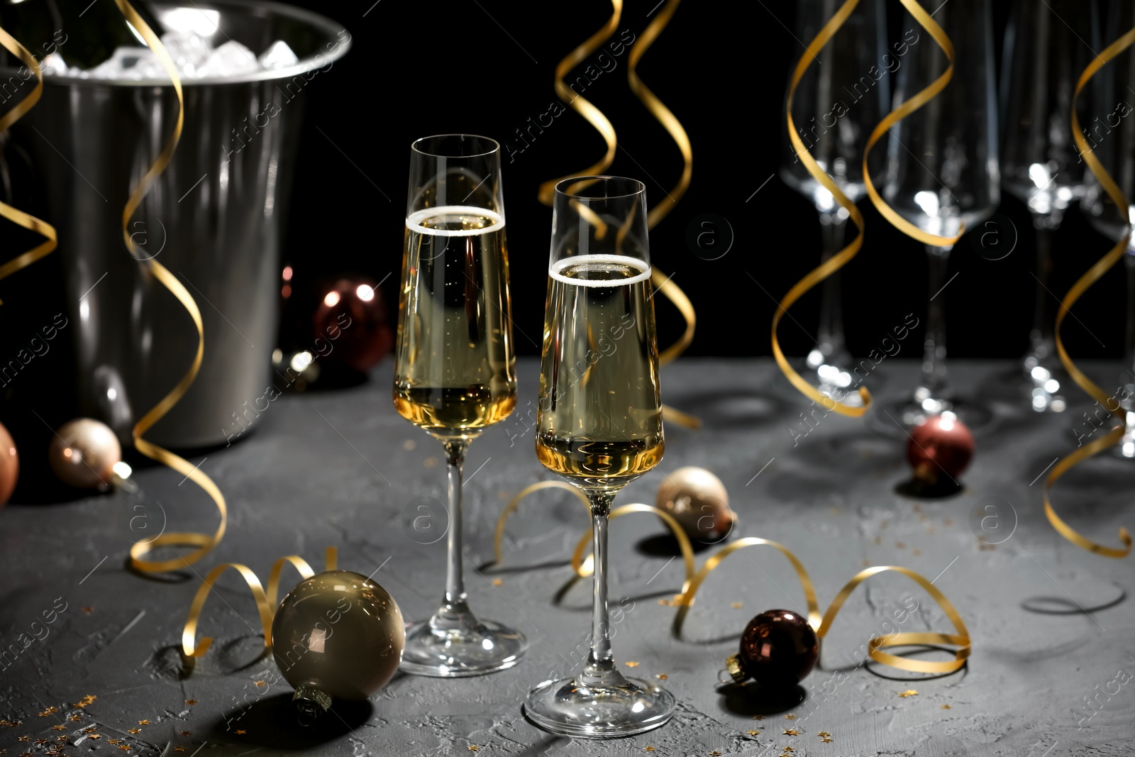 Photo of Champagne in glasses and decor on grey table. Christmas celebration