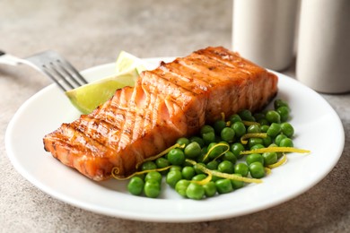 Photo of Delicious grilled salmon fillet served on grey table, closeup