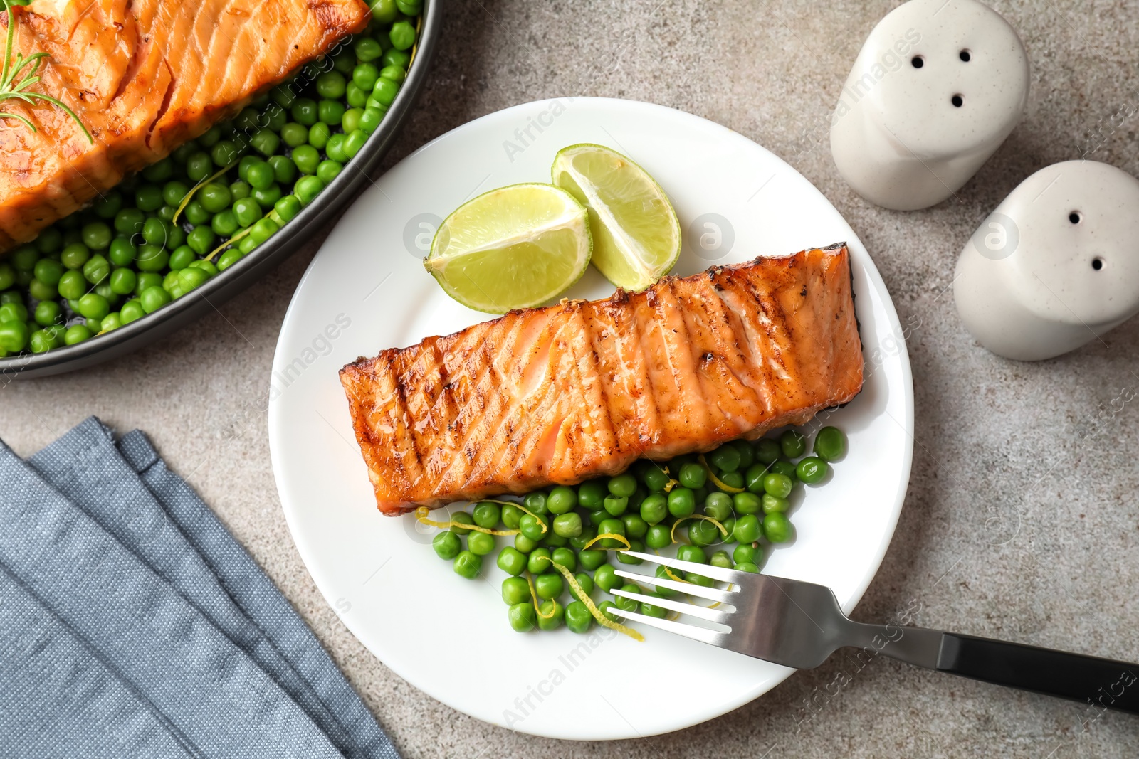 Photo of Delicious grilled salmon fillet served on grey textured table, flat lay