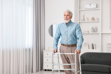 Senior man using walking frame at home. Space for text