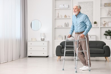 Photo of Senior man using walking frame at home