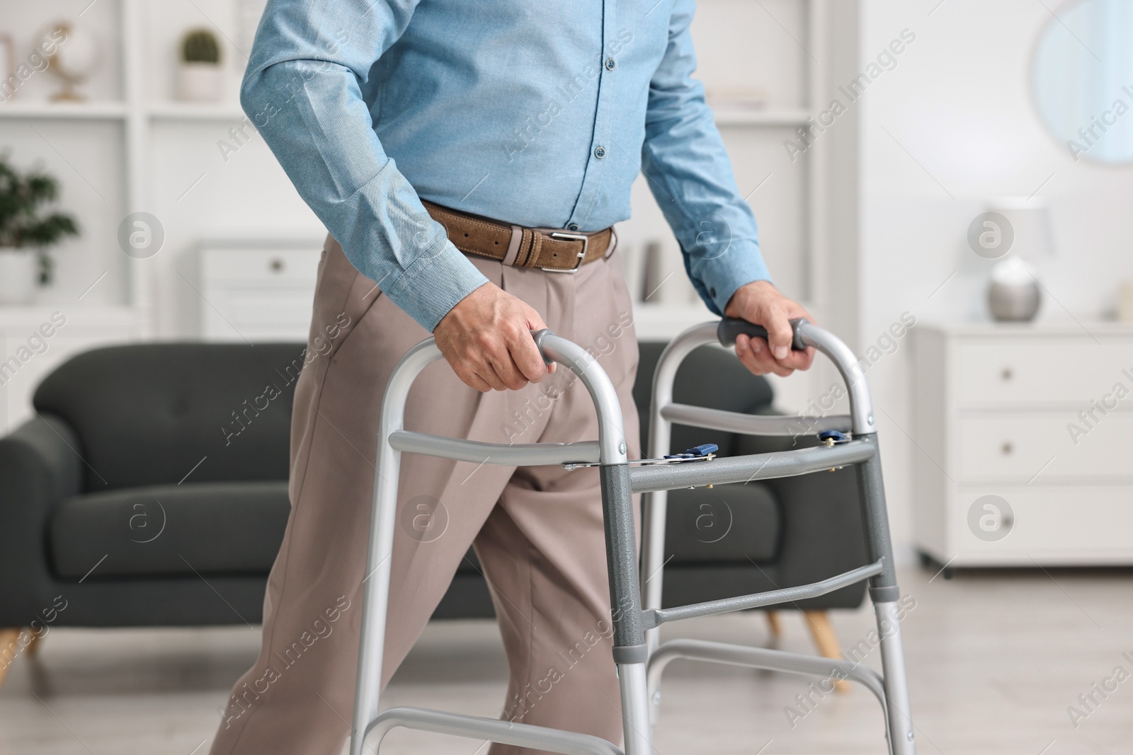 Photo of Senior man using walking frame at home, closeup