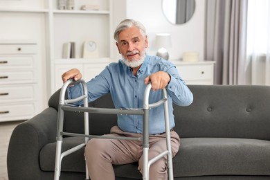 Photo of Senior man with walking frame on sofa at home